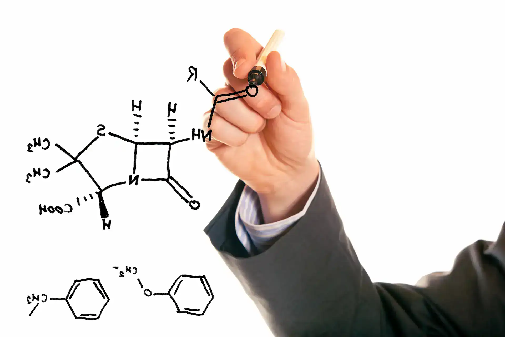 A hand drawing science sketches in black dry erase marker.