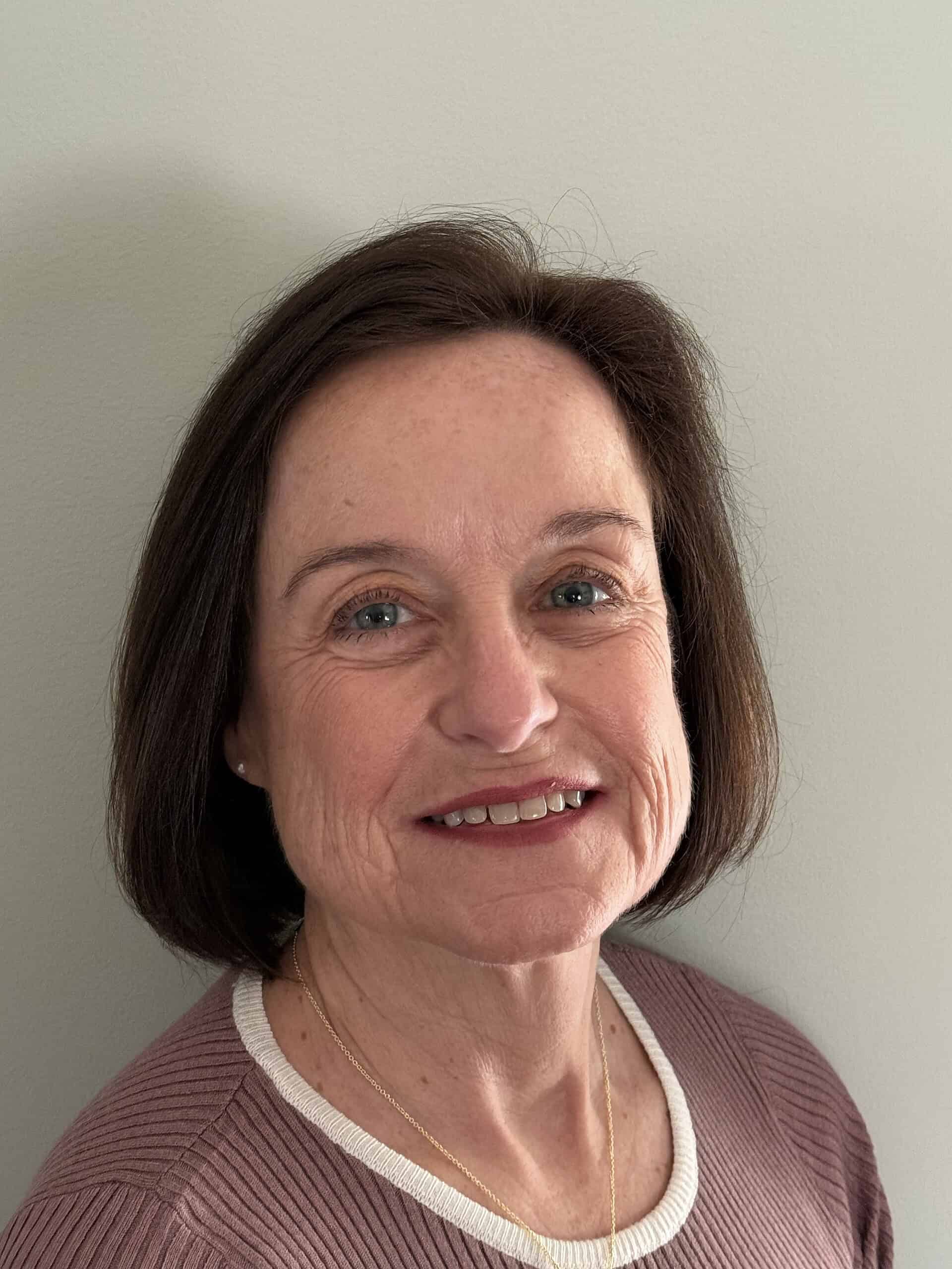 Confident woman smiling, professional corporate headshot for business and consulting services.